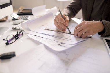 Kalem ve cetvel çizimli mimarın elleri, yeni bina projesini işyerine göre çizerken