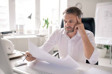 Olgun düşünceli mühendis fikirleri düşünürken çizime bakar ya da ofisteki işyerine göre kontrol eder.