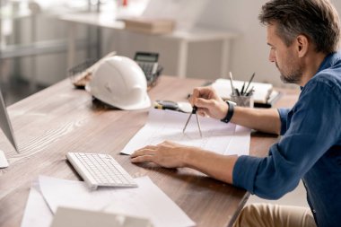 Ofisteki yeni mimari yapının taslağını çizerken bölücüleri kullanan gelişigüzel bir mühendis.