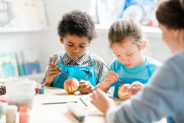 Escuelas Serias Sentadas Por Escritorio Entre Sus Compañeros Clase Pintando —  Fotos de Stock