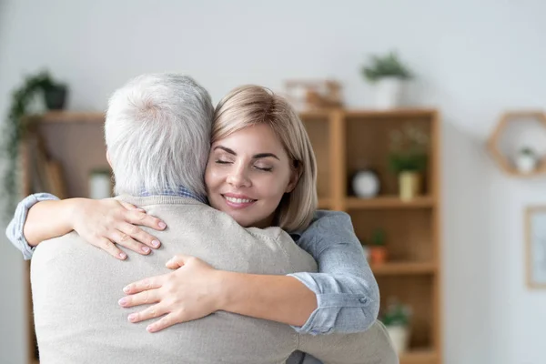 Young Blonde Affectionate Woman Toothy Smile Closed Eyes Embracing Her — Stockfoto