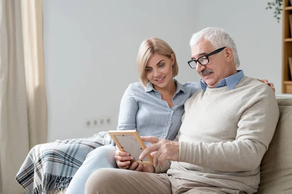 Senior Man Casualwear Pointing Photo Frame While Discussing His Young — Stock Photo, Image