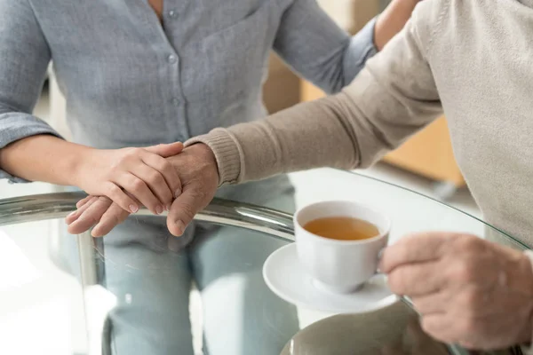 Cuidadosa Hija Joven Cogida Mano Padre Jubilado Tomando Una Taza — Foto de Stock