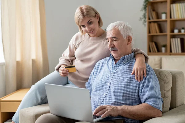 Junge Frau Mit Kreditkarte Umarmt Ihren Älteren Vater Mit Laptop — Stockfoto