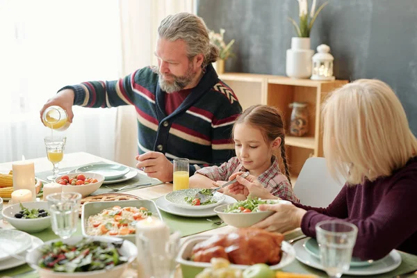 Senior Man Pouring Orange Juice Glass Festive Table Family Dinner — ストック写真