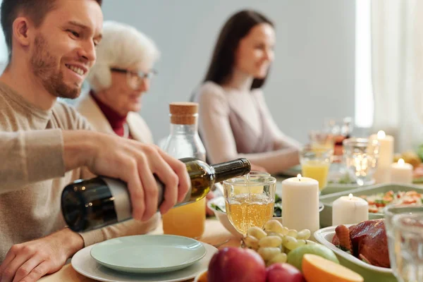 Young Man Pouring Wine Wineglass While Sitting Served Table Family — Stok fotoğraf