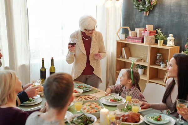 Старшая Женщина Бокалом Красного Вина Произносит Праздничный Тост Семейным Ужином — стоковое фото
