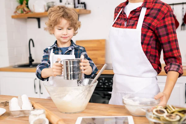 Cute Little Boy Sifting Flour While Standing Table Next His — 스톡 사진