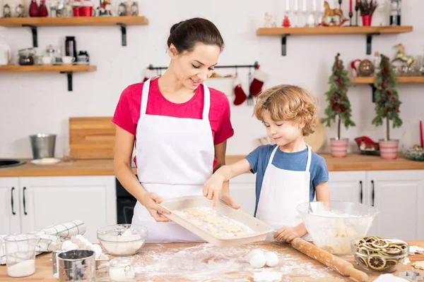 Leuke Krullende Jongen Wijzend Naar Een Van Koekjes Dienblad Terwijl — Stockfoto