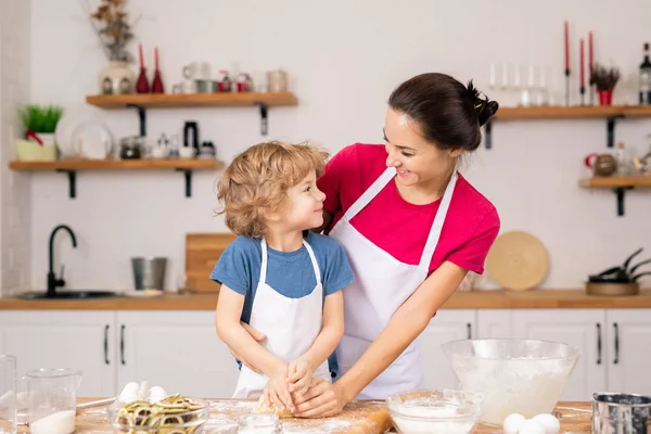 Netter Glücklicher Junge Der Seine Mutter Ansieht Während Ihr Hilft — Stockfoto