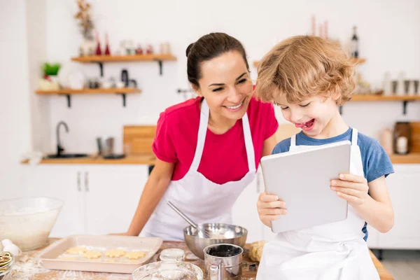 Adorable Joyful Child Touchpad Showing His Mom Video Recipe Something — Stok fotoğraf