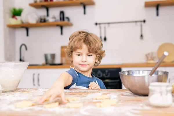 Cute Little Boy Apron Stretching Hand One Raw Cookies Table — Stock Photo, Image