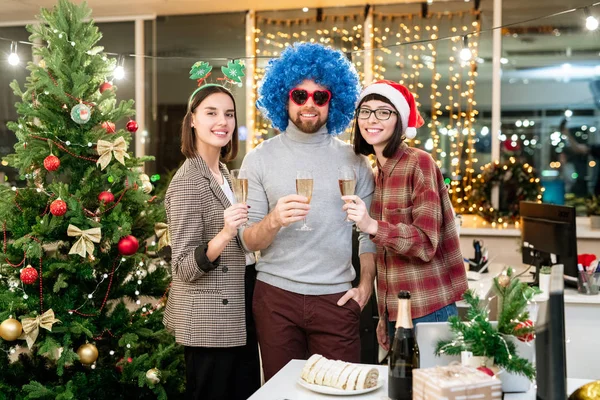 一群快乐的年轻人一边在办公室里享受派对 一边用香槟酒为圣诞祝酒 — 图库照片