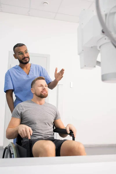 Doctor Blue Uniform Showing Patient Wheelchair New Medical Equipment While — Stockfoto