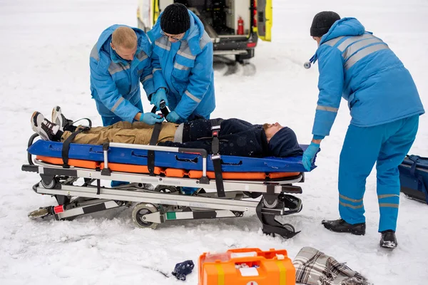 Two Young Paramedics Blue Workwear Fixing Unconscious Man Belts Stretcher — Stock Photo, Image