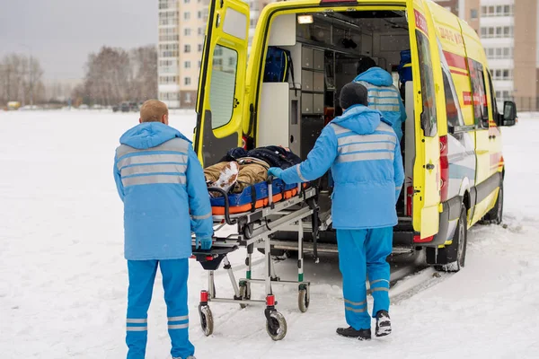 Zwei Junge Sanitäter Blauer Arbeitskleidung Schieben Bahre Mit Bewusstlosem Mann — Stockfoto