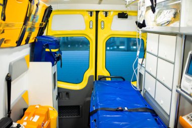 Interior of contemporary ambulance car with stretcher, dropper, first aid kit and other medical equipment