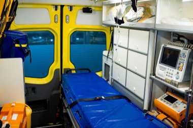 Interior of contemporary ambulance car with stretcher, dropper, first aid kits, refrigerator and medical equipment