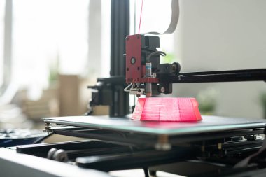 Yazdırma işlemi sırasında pembe yuvarlak nesnenin temeli üzerinde hareket eden 3D yazıcı başlığı