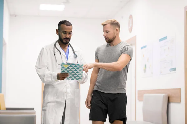 Jovem Desportista Consulta Com Seu Médico Apontar Ponto Prescrição Documento — Fotografia de Stock