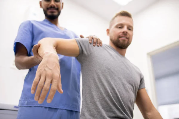 Young Professional Masseur Blue Uniform Holding Sick Arm Patient While — Stok fotoğraf