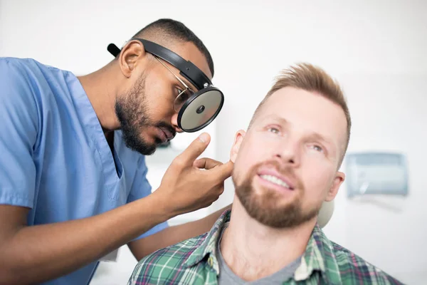 Młody Profesjonalny Lekarz Niebieskim Mundurze Noszący Specjalny Sprzęt Głowie Podczas — Zdjęcie stockowe