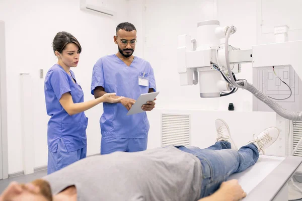 Two Young Clinicians Blue Uniform Discussing Online Data Touchpad While — ストック写真