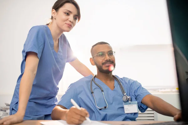 Junge Erfolgreiche Ärzte Uniform Schauen Auf Den Computerbildschirm Während Sie — Stockfoto
