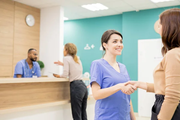 Bastante Joven Sonriente Clínico Estrechando Mano Paciente Femenina Fondo Niña — Foto de Stock