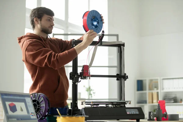 Jongeman Zet Nieuwe Spoel Met Rode Gloeidraad Printer Terwijl Hij — Stockfoto