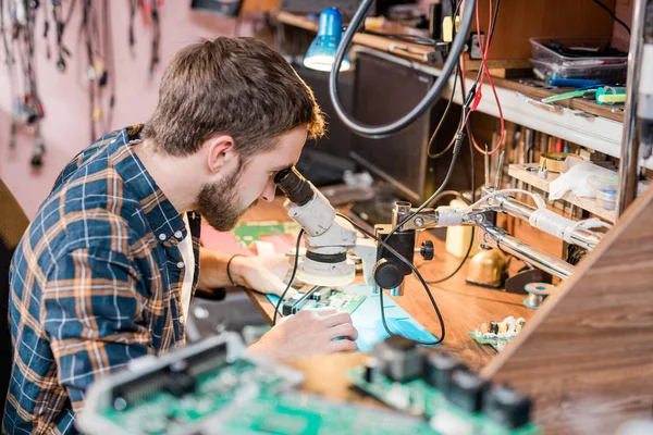 Riparatore Gadget Professionale Guardando Microscopio Dal Posto Lavoro Durante Tentativo — Foto Stock