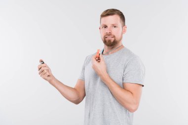 Sakallı genç spor eğitmeni ya da hakem ıslıkla kameranın önünde tek başına dikilirken sana bakıyor.