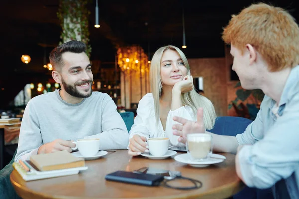 Szczęśliwa Młoda Heteroseksualna Para Rozmawiająca Swoim Przyjacielem Filiżanką Cappuccino Podczas — Zdjęcie stockowe