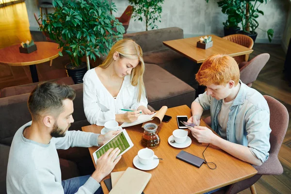 Grupo Estudantes Ocupados Sentados Mesa Café Após Aulas Caras Usando — Fotografia de Stock