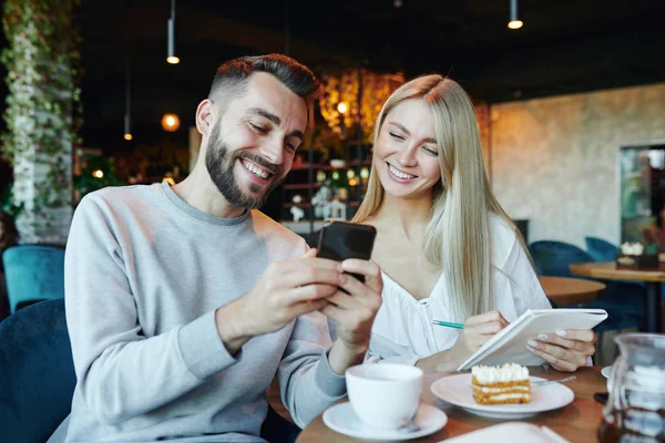 Junges Fröhliches Paar Blickt Auf Smartphone Bildschirm Während Tisch Café — Stockfoto