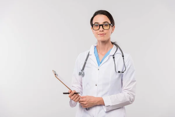 Pretty Young Confident Clinician Whitecoat Holding Clipboard Document While Standing — Stock Photo, Image
