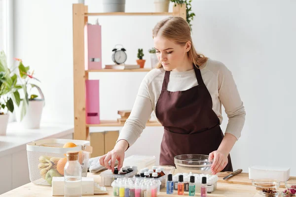 Young Blonde Woman Taking One Bottles Essential Oils While Choosing — Stock Photo, Image