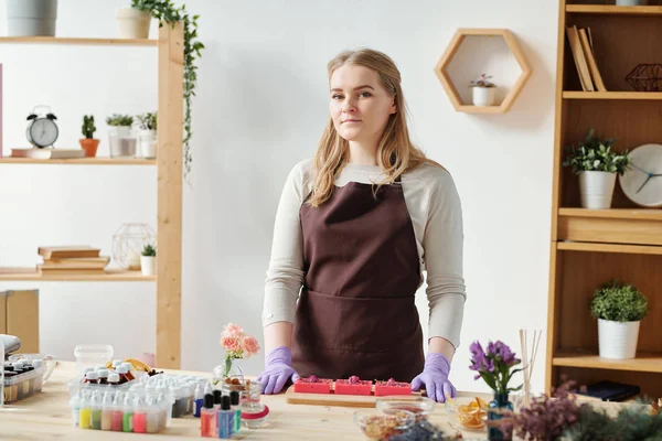 Chica Bonita Delantal Guantes Mirándote Mientras Estás Pie Junto Mesa — Foto de Stock