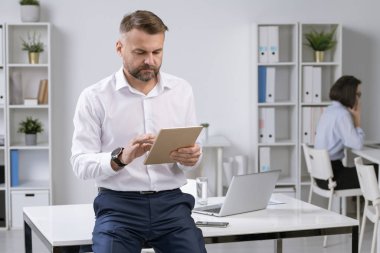 Ciddi bir ofis çalışanı ya da resmi kıyafet işvereni gerekli bilgiler için internette sörf yaparken dokunmatik ped kullanıyor