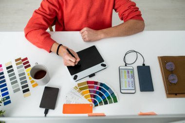 Çalışma masasının rötuş sırasında grafik tableti ekranı üzerinde stilus ile genç erkek web tasarımcısının elleri