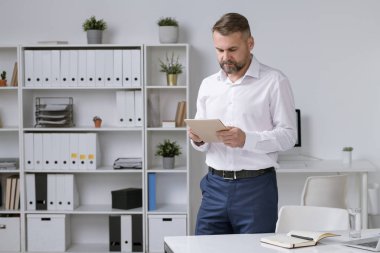 Çevrimiçi veri ararken veya ofiste webinar izlerken dijital tablette kayan kendinden emin bir girişimci