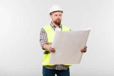 Başarılı mühendis ya da koruyucu miğferli ustabaşı ve taslak çizimine bakarken önündekileri tutan iş elbisesi tasarımcısı.