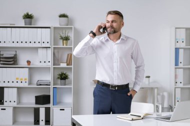 Ciddi ve kendine güveni tam bir girişimci. İş ortağına ya da müşteriye danışırken akıllı telefonu kulağının dibinde tutuyor.