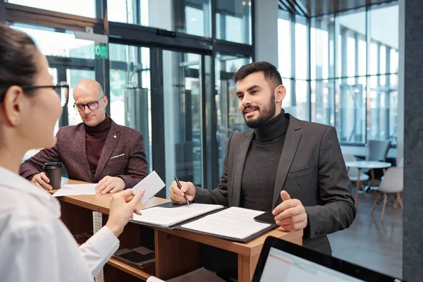 Bearded Young Businessman Pen Looking Female Receptionist While Filling Form — Stockfoto