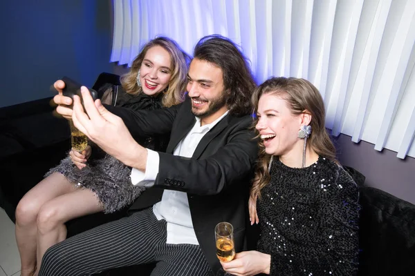 Vrolijke Jonge Glamoureuze Vrouwen Met Champagne Elegante Man Met Smartphone — Stockfoto