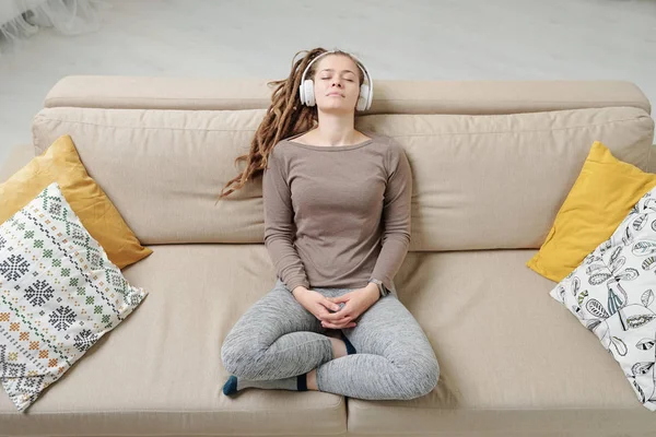 Young Restful Woman Activewear Sitting Couch Listening Peaceful Music Headphones — 스톡 사진