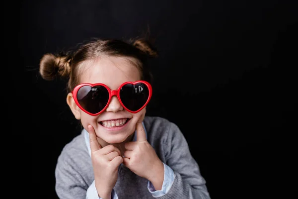 Cute Wesoły Dziewczyna Zębaty Uśmiech Patrząc Przez Stylowe Okulary Przeciwsłoneczne — Zdjęcie stockowe