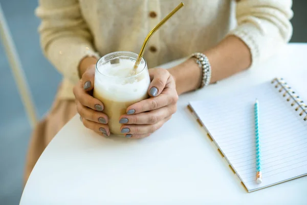 Mani Studentessa Possesso Bicchiere Cappuccino Con Paglia Mentre Siede Tavola — Foto Stock