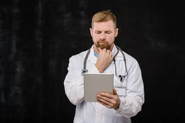 Pensive Young Doctor Whitecoat Phonendoscope Neck Looking Online Data Tablet — 스톡 사진