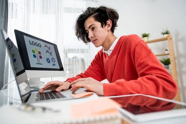Giovane Web Designer Utilizzando Computer Portatile Mentre Seduto Davanti Monitor — Foto Stock